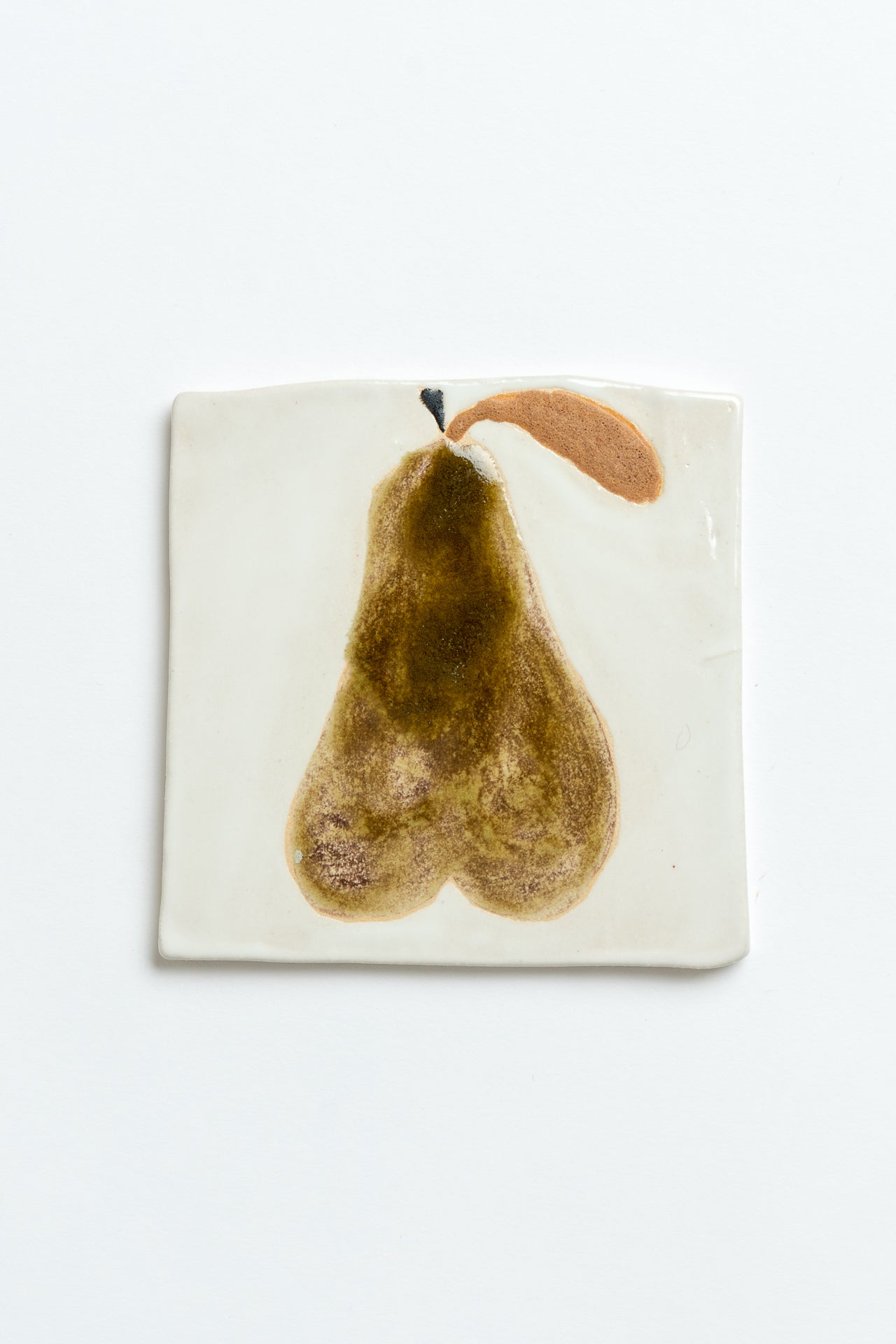 Coaster with a pear design on a white background hand made by contemporary British ceramicist Studio Alice Johnson in collaboration with MIMMO Studios