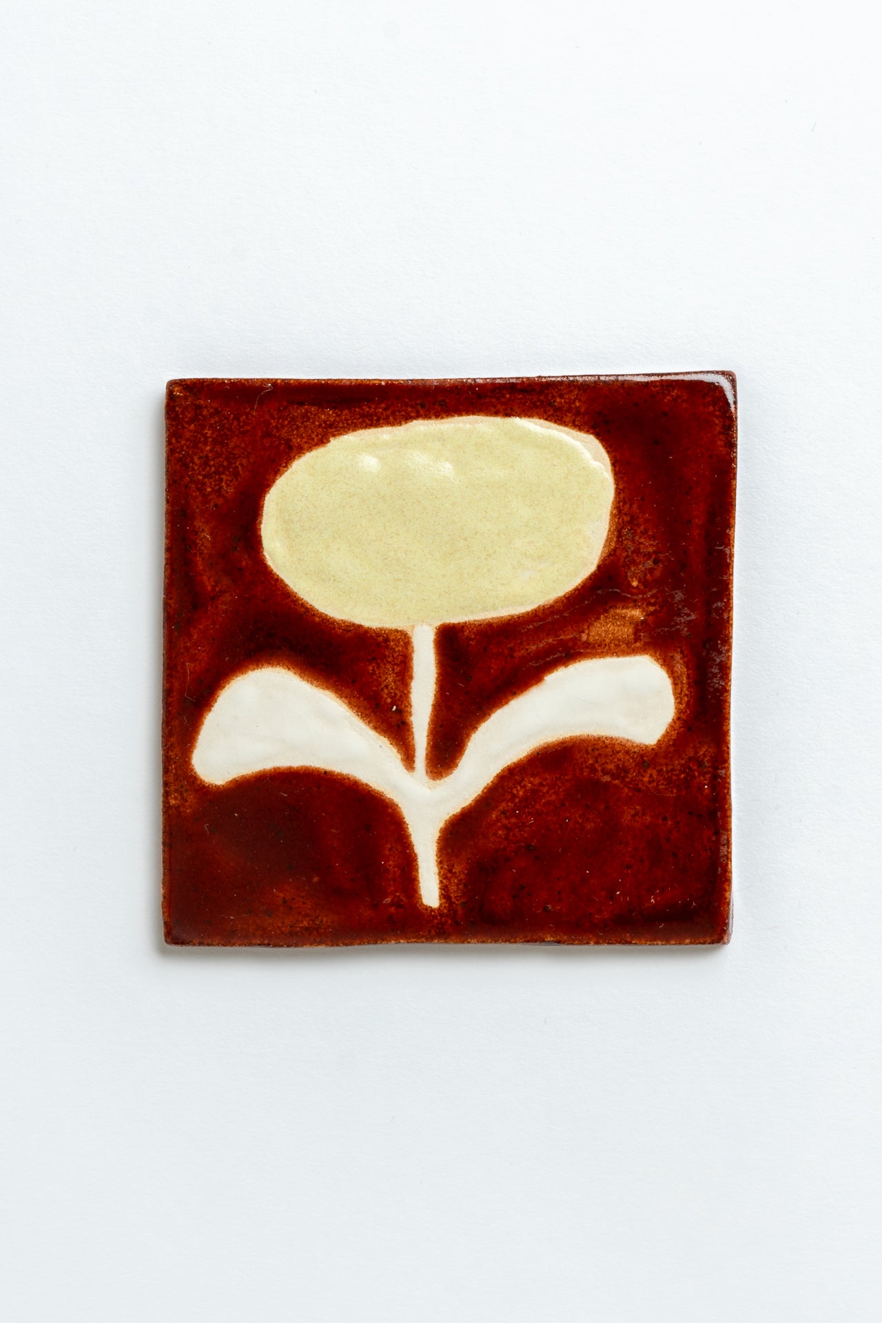 Square ceramic tile with a floral design on a white background by contemporary British ceramicist Studio Alice Johnson