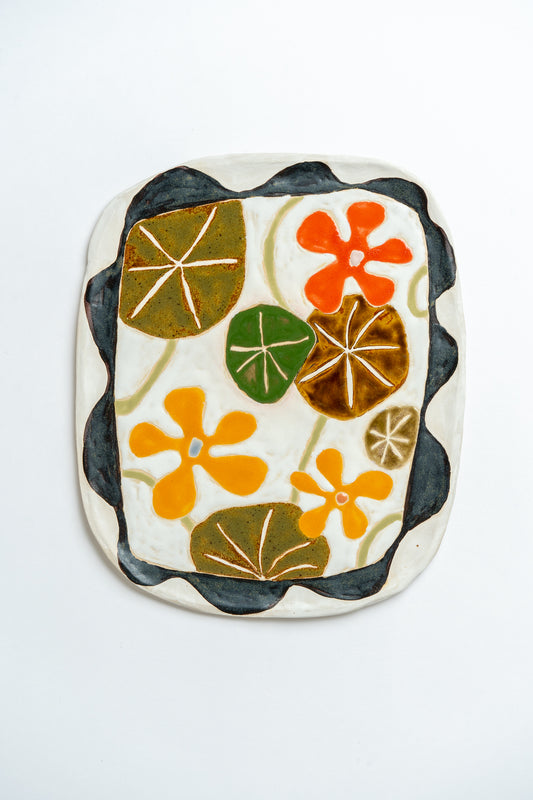 Ceramic tile with floral nasturtium design on a white background by contemporary British ceramicist Studio Alice Johnson