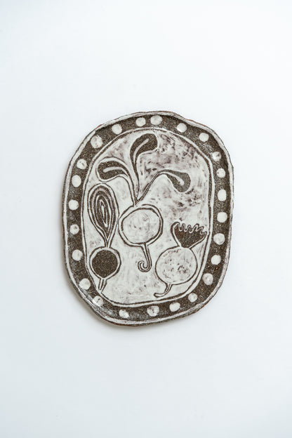 Decorative ceramic plate with vegetable design on a white background by British contemporary ceramicist Studio Alice Johnson