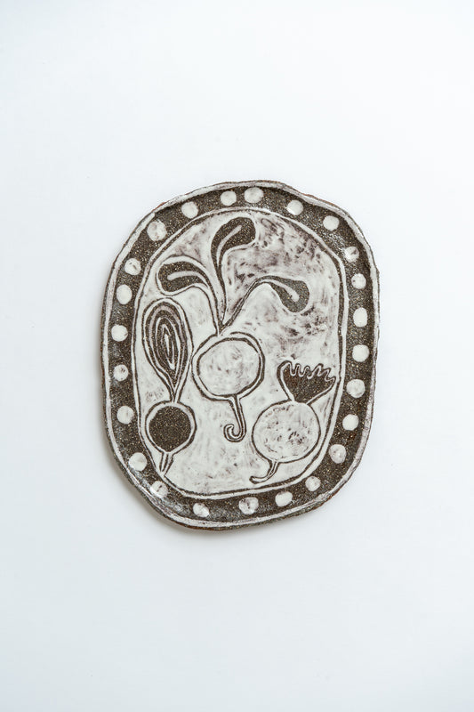 Decorative ceramic plate with vegetable design on a white background by British contemporary ceramicist Studio Alice Johnson