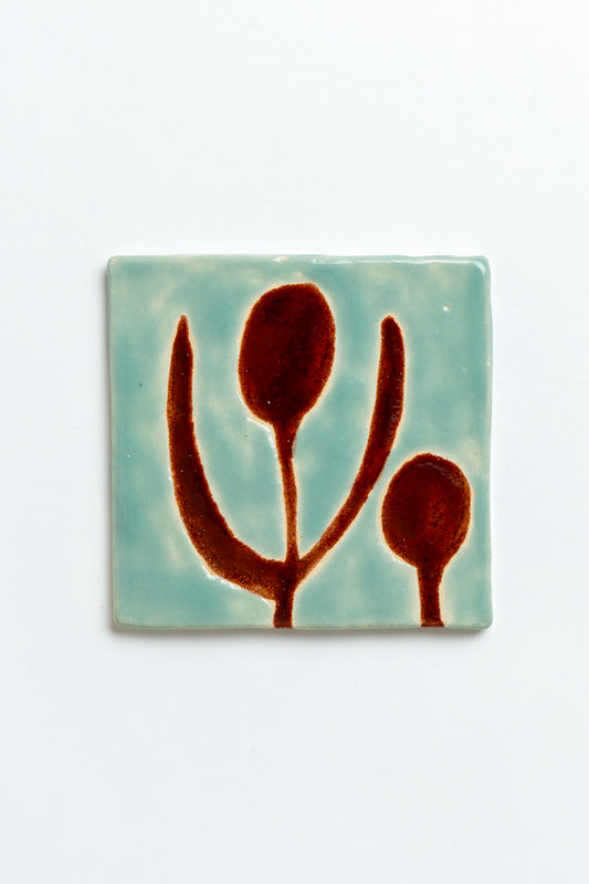 Square ceramic tile with brown abstract design on a light blue background. MIMMO Studios x Studio Alice Johnson ceramics collaboration.