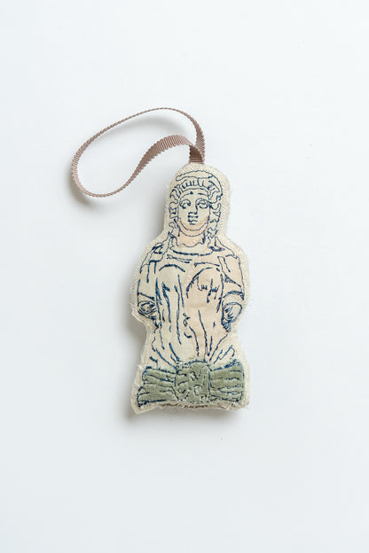 Decorative Christmas decoration shaped like a classical figure on a white background, inspired by the caryatid stone ladies in Montpellier Cheltenham. Iconic landmark. MIMMO Studios x Ludio Christmas collaboration