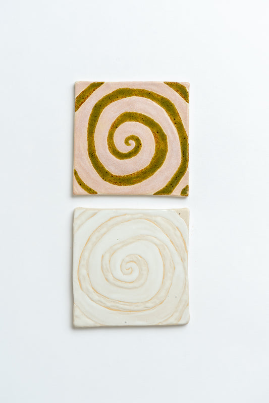 Two square tiles with spiral patterns on a white background handmade by contemporary British ceramicist Studio Alice Johnson