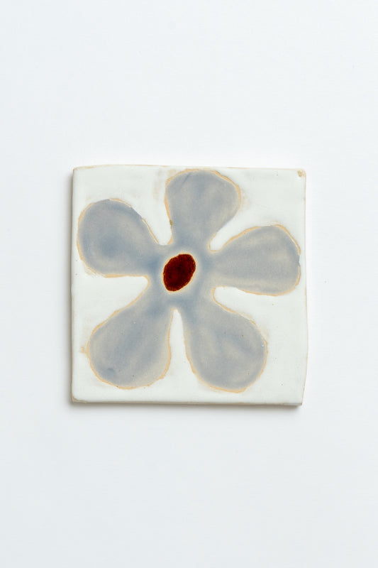 Ceramic tile with a blue flower design on a white background handmade by contemporary British ceramicist Studio Alice Johnson in collaboration with MIMMO Studios