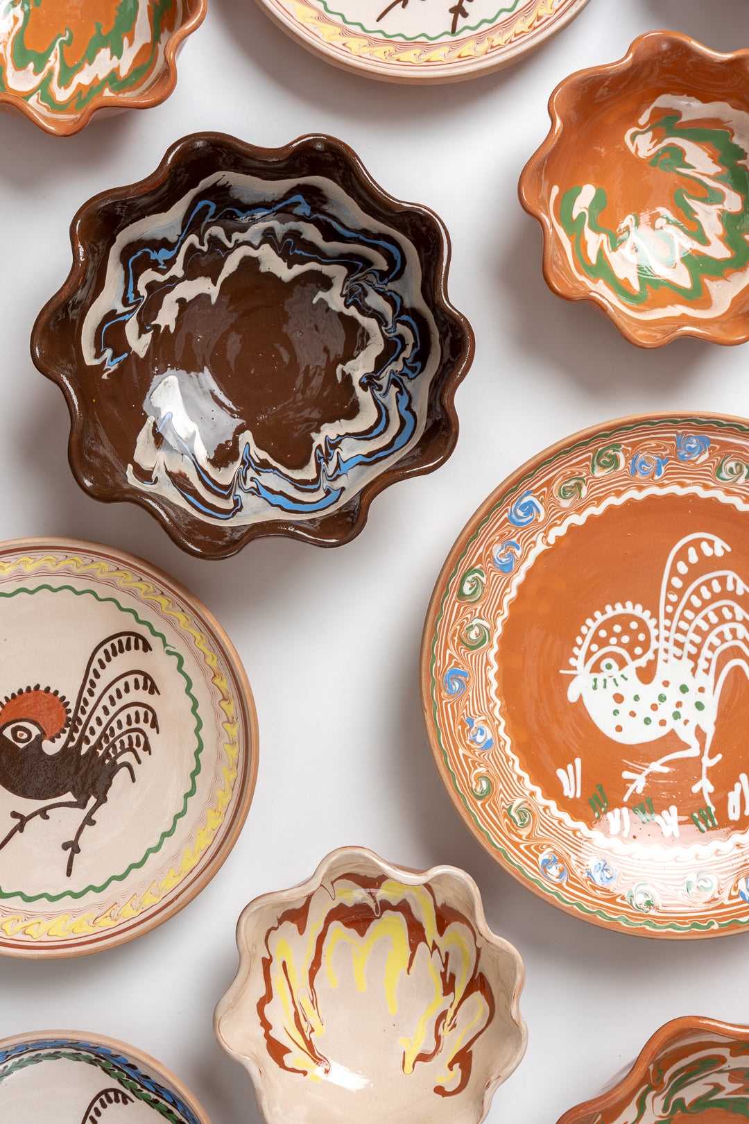 A medium-sized, handcrafted ceramic bowl with a marbled design featuring brown, blue, and white colors, and a unique frill edge. MIMMO Studios x Casa De Folklore collaboration